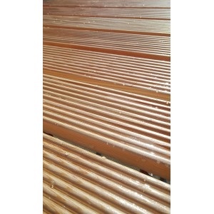 Griglia doccia in legno, superficie scanalata con gocce d'acqua.