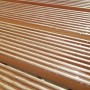 Griglia doccia in legno, superficie scanalata con gocce d'acqua.