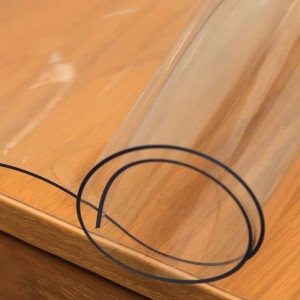 Tovaglia trasparente (t.b.t.) su tavolo di legno, arrotolata.