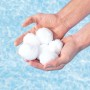 Mani che tengono palline filtranti bianche per filtri piscina. Accessori per acqua pulita.
