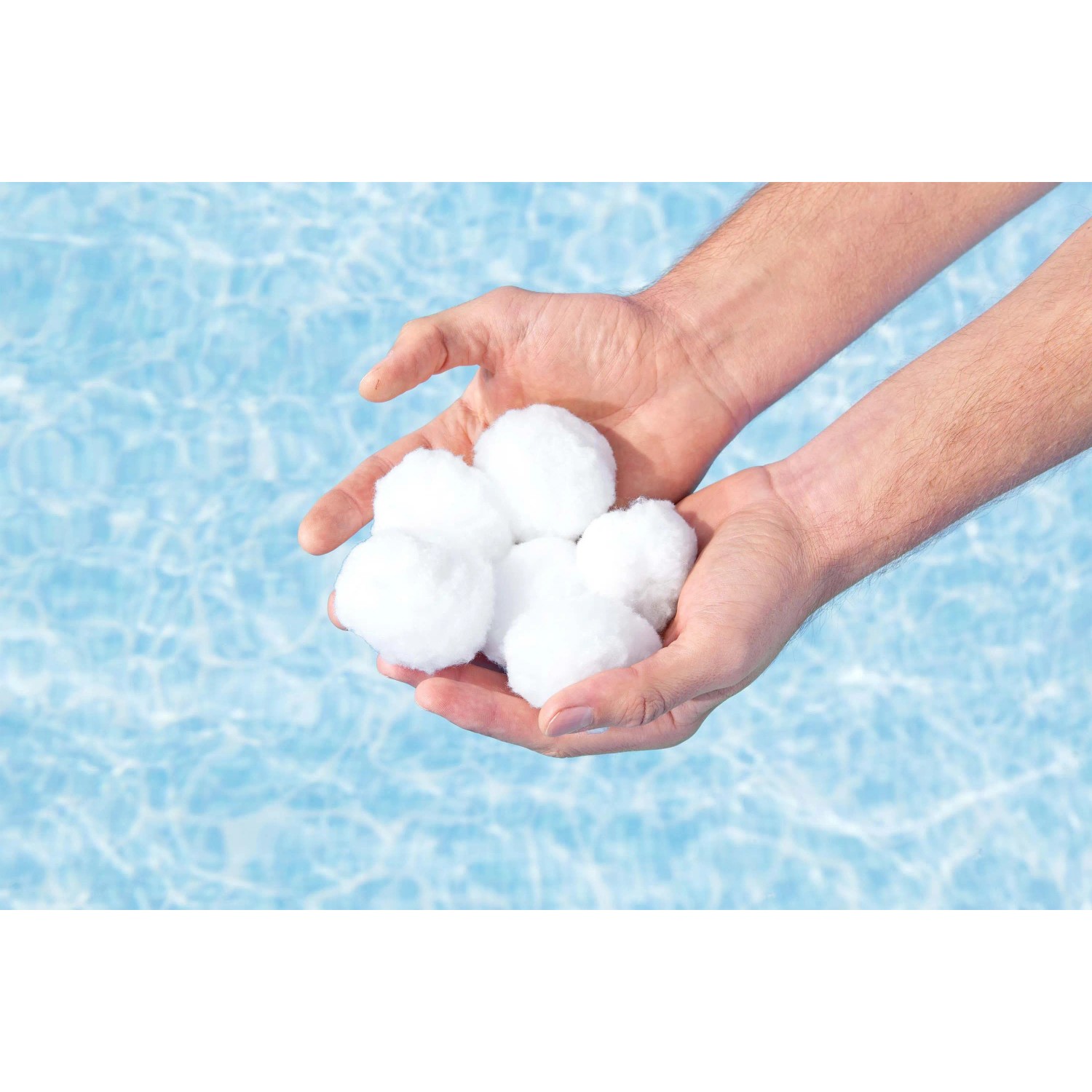Mani che tengono palline filtranti bianche per filtri piscina. Accessori per acqua pulita.