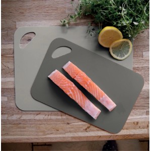 Due taglieri t.b.t. grigi con manico, uno con filetto di salmone, limone ed erbe aromatiche.