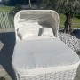 Lettino prendisole t.b.t. grigio con baldacchino e cuscini in giardino.