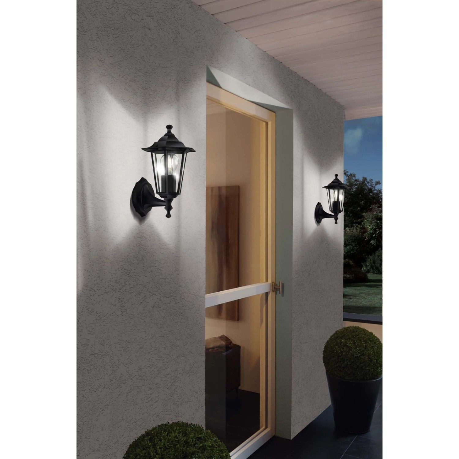 Lampade da parete per esterni t.b.t. nere in stile classico su una parete di casa.