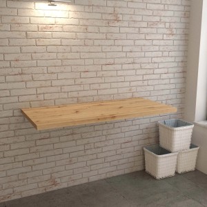 Mensola lavabo t.b.t. in legno chiaro su parete di mattoni bianchi.