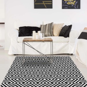 Tappeto moderno con motivo a rombi bianco e nero in soggiorno.