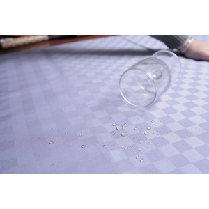 Tovaglia a scacchi idrorepellente con bicchiere rovesciato e gocce d'acqua.