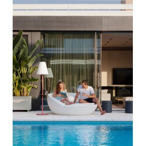 Scena con lampada da esterno t.b.t. e mobili lounge a bordo piscina.