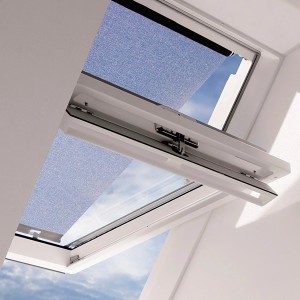 Tenda parasole Velux MHL CK00 su finestra per tetto, parzialmente aperta, cielo blu visibile.