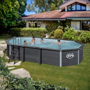 Piscina ovale Gre Composite Avantgarde (664x386x124 cm) con bagnanti e scaletta in giardino.