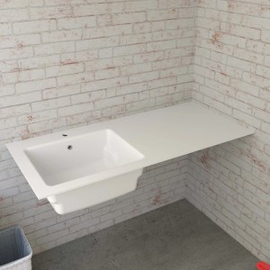 Lavandino bianco t.b.t. con ripiano davanti a un muro di mattoni.