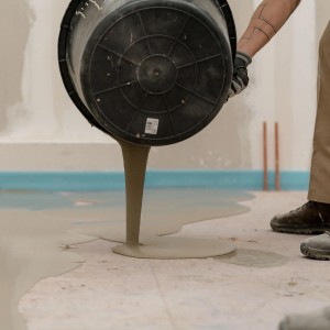 Massetto autolivellante Mapei versato da un secchio. Massetti per interni ed esterni.