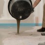 Massetto autolivellante Mapei versato da un secchio. Massetti per interni ed esterni.