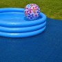 Piscina blu con palla su piastrelle scure per esterni.
