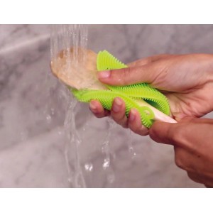 Spugna t.b.t. verde pulisce cucchiaio di legno sotto l'acqua corrente.