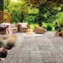 Terrazza con pavimentazione per esterno t.b.t. e mobili da giardino nel verde.