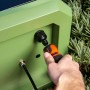 Pompa a pressione collegata all'armadietto da giardino verde.