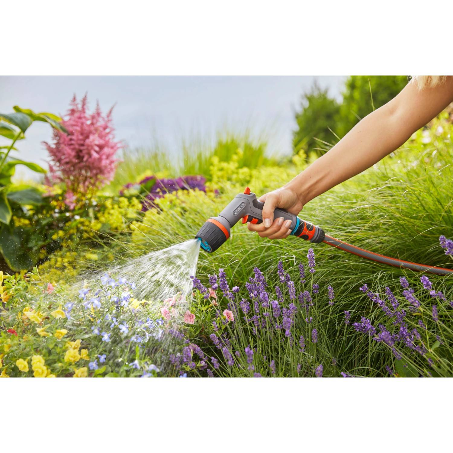 Gardena Comfort Cleaning Sprayer ecoPulse™ in azione: irrigazione di fiori in giardino.