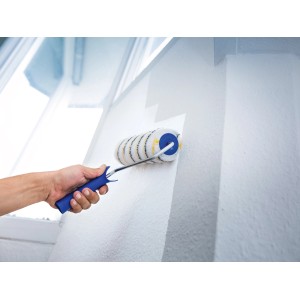 Mano che dipinge parete bianca con rullo per pittura LUX 18 cm Polymix oro-grigio a righe.