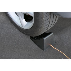 Cuneo nero sotto una ruota come accessorio auto.