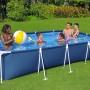 Piscina fuori terra rettangolare con famiglia e giochi da spiaggia in giardino.