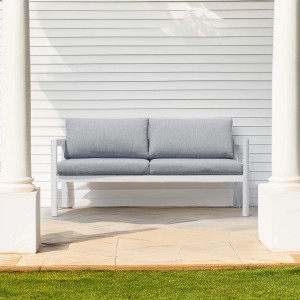 Divano da esterno bianco con cuscini grigi. Arredo per terrazza e giardino.