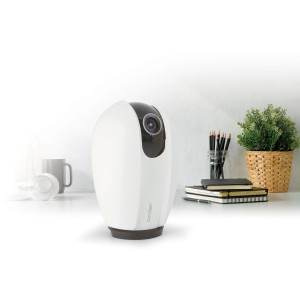 Telecamera di videosorveglianza t.b.t. bianca su una scrivania con decorazioni.