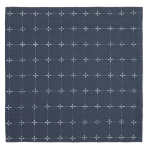 t.b.t. Tovaglia blu scuro con motivo a croce bianca.