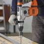 Trapano a percussione Black+Decker BEHS03K in azione durante la foratura del metallo.