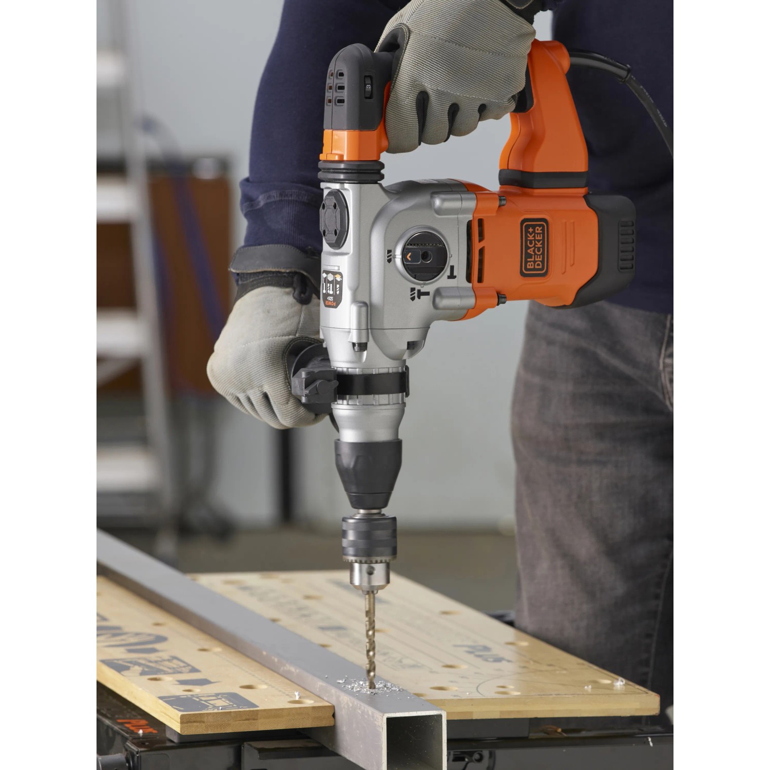 Trapano a percussione Black+Decker BEHS03K in azione durante la foratura del metallo.