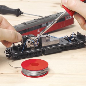 Saldatore LUX 15 W in uso per saldare componenti elettronici, con stagno e utensili.