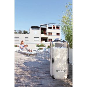 Sistema di microirrigazione t.b.t. su una terrazza sul tetto con una donna su una sedia a sdraio sullo sfondo.