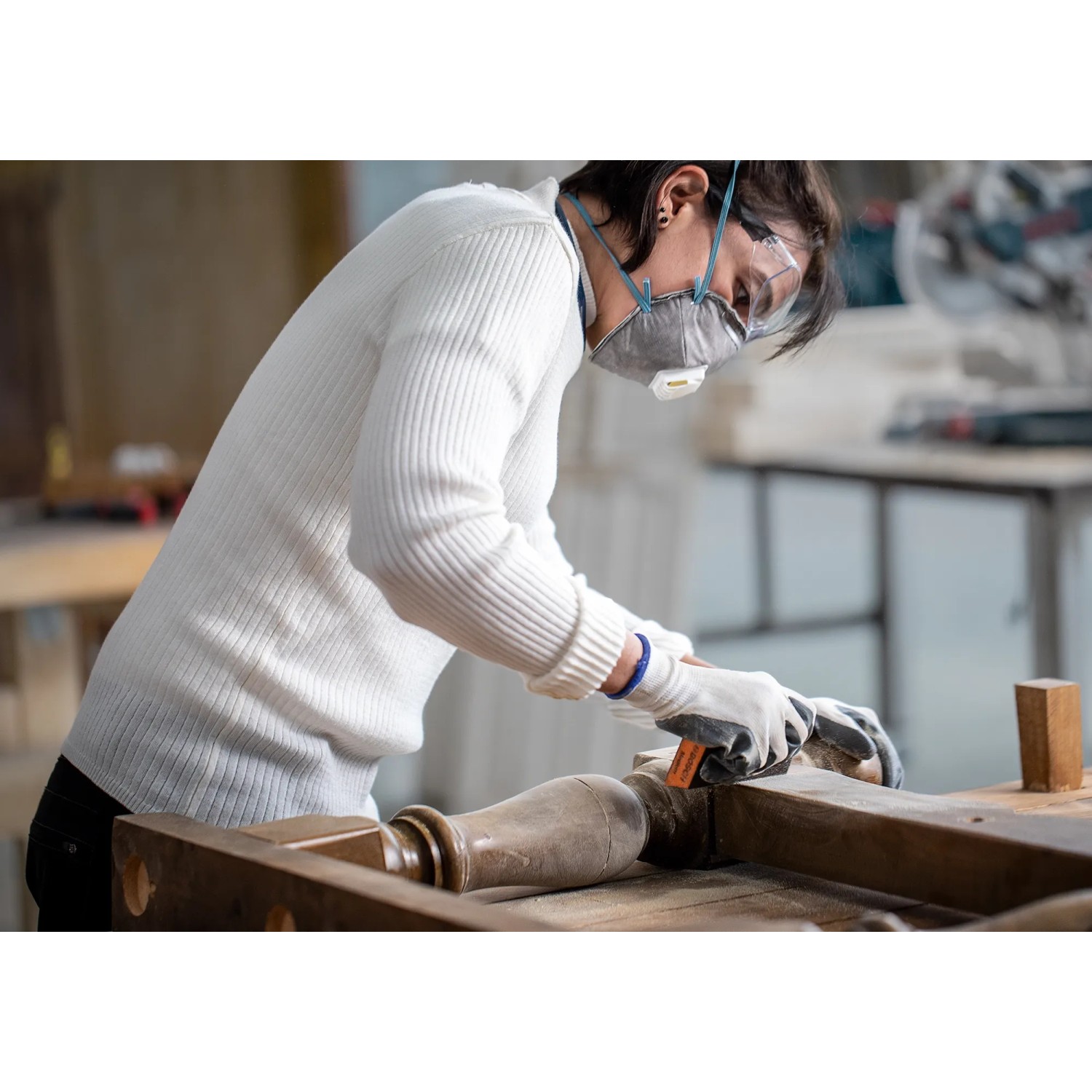 Donna che leviga il legno con spugna abrasiva Bosch Expert. Abrasivi per legno e vernice.