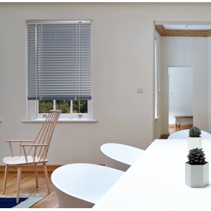 Veneziana t.b.t. grigia alla finestra in una stanza luminosa.