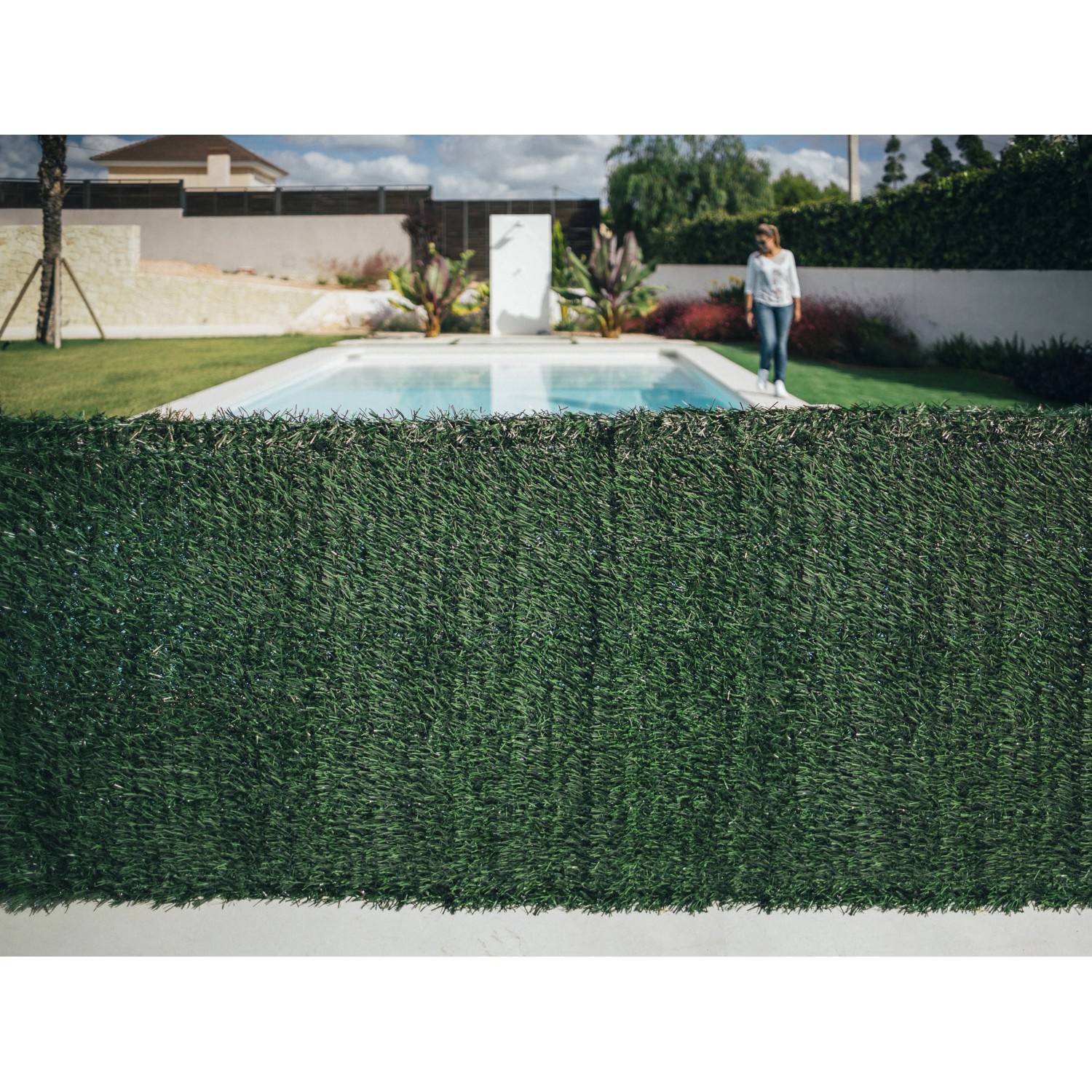 Schermo verde t.b.t. per la privacy in giardino con piscina e persona. Ideale come arelle, ombra e protezione dal vento.