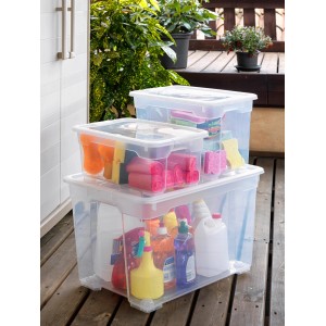 Contenitori trasparenti t.b.t. di diverse dimensioni, riempiti con prodotti per la pulizia e spugne.