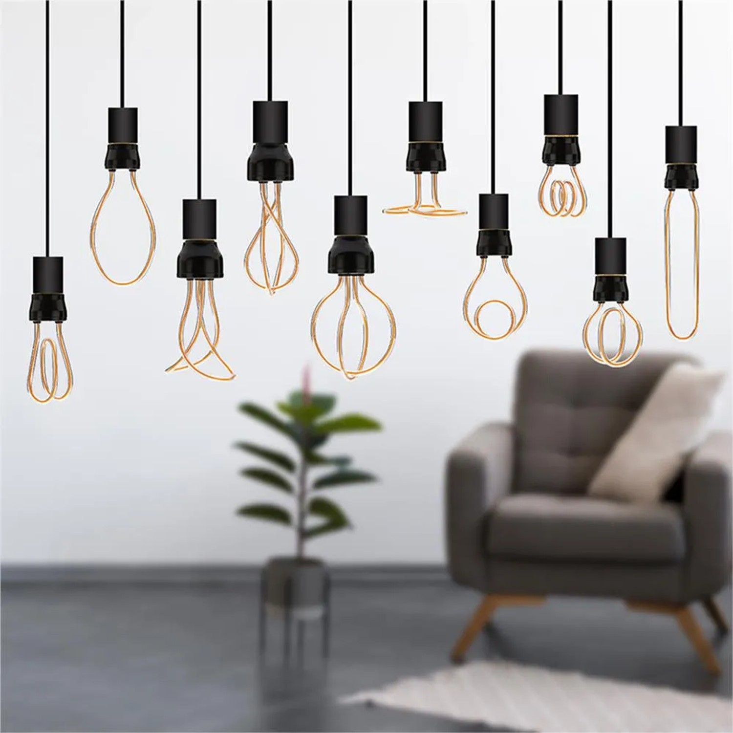 Lampadine LED E27 decorative in varie forme, sospese davanti a uno sfondo di soggiorno.