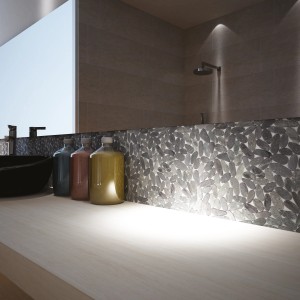 Piastrelle mosaico in bagno con effetto pietra naturale e lavabo.
