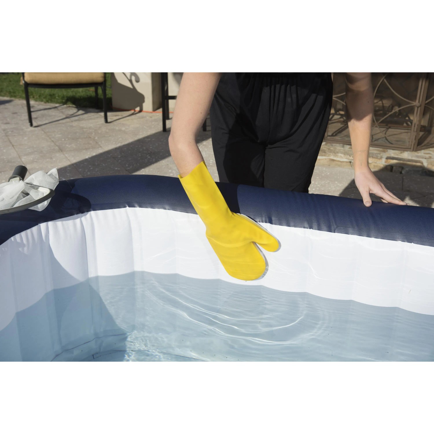 Guanto giallo per la pulizia della piscina in uso. Accessorio per piscina.