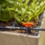 Sistema di irrigazione con raccordo t.b.t. e valvola arancione in fioriera.