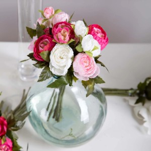 Fiori artificiali decorativi in vaso di vetro, fiori rosa e bianchi.