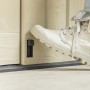 Piede che aziona la chiusura della scatola universale t.b.t. su porta in legno.