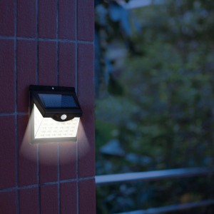 Faretto da parete a LED t.b.t. illuminato come segnapasso su un muro di mattoni rossi.