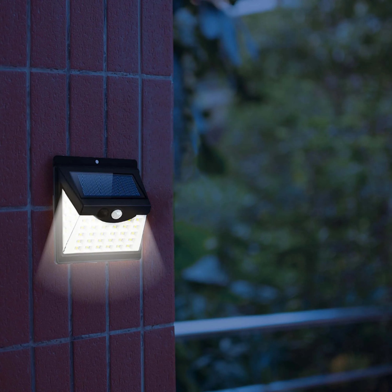 Faretto da parete a LED t.b.t. illuminato come segnapasso su un muro di mattoni rossi.