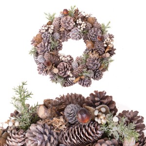 Ghirlanda natalizia decorativa fatta di pigne, noci e bacche per le feste.