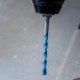 Punta Bosch Expert Multi Construction CYL-9 in uso, punta universale con spirale blu.