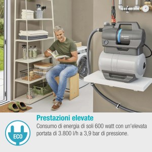 Pompa da giardino grigia in interni con uomo che legge. Pompa elettrica per irrigazione giardino.
