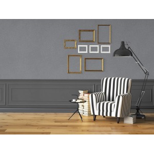 Soggiorno con pittura decorativa grigia, cornici, poltrona a righe e lampada da terra.