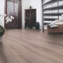 Pavimento in laminato di rovere chiaro con struttura in legno antico, posato in un soggiorno.