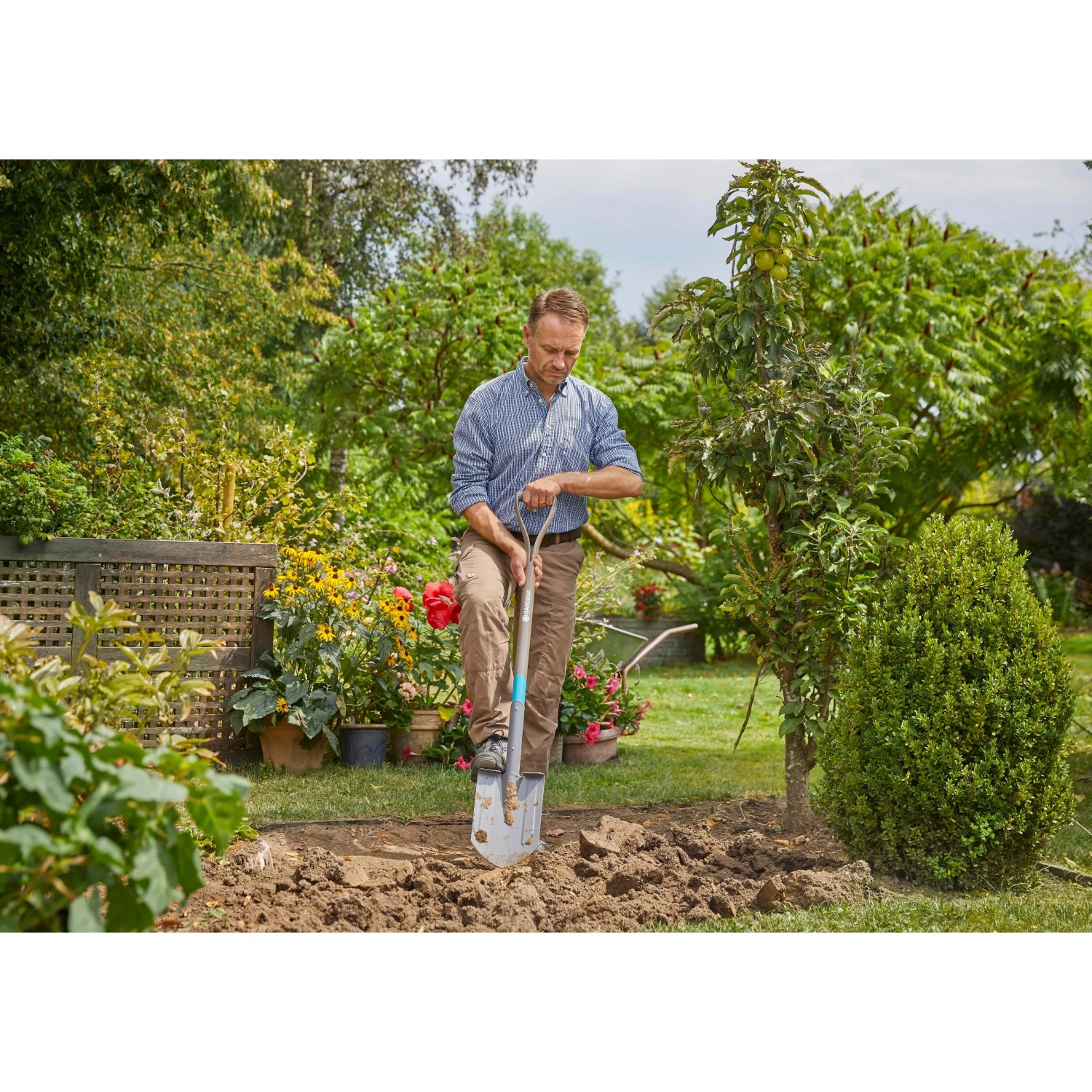 Uomo che scava in giardino con una pala. Attrezzi da giardinaggio per il giardinaggio.